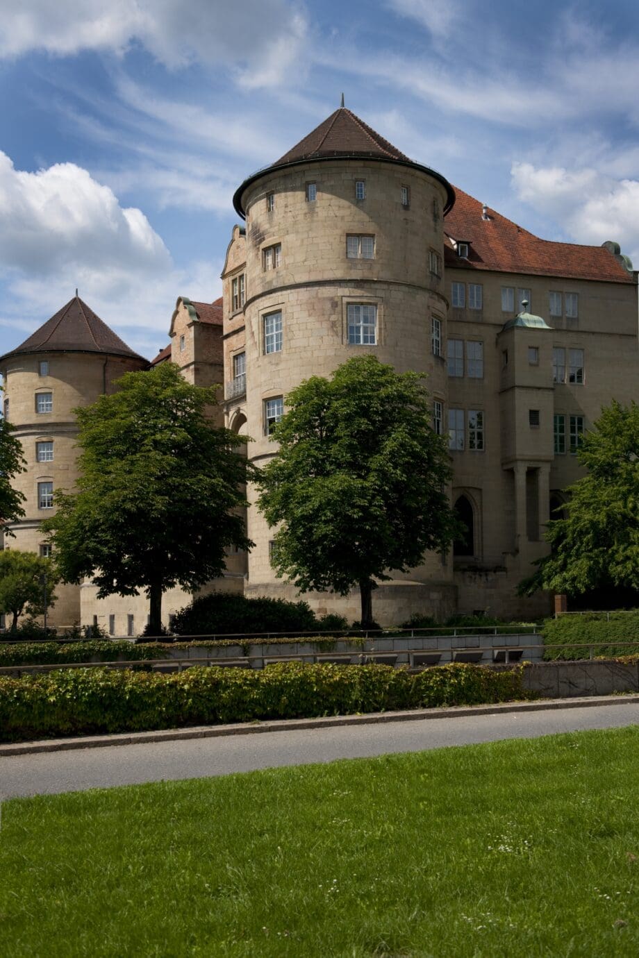 Ansicht des Alten Schlosses mit grünen Rasenflächen und Bäumen